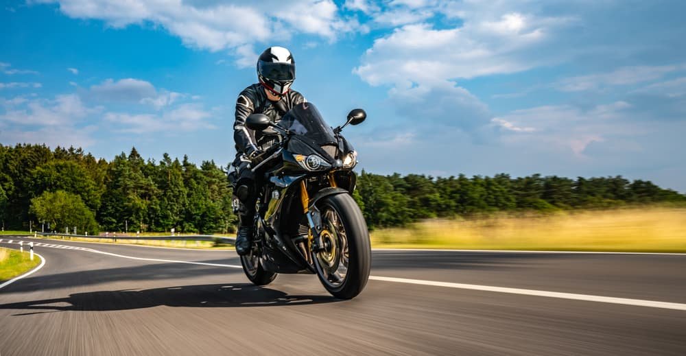 Lane splitting legality for motorcycles in Illinois explained Motorcyclist riding on an Illinois highway while following traffic laws.