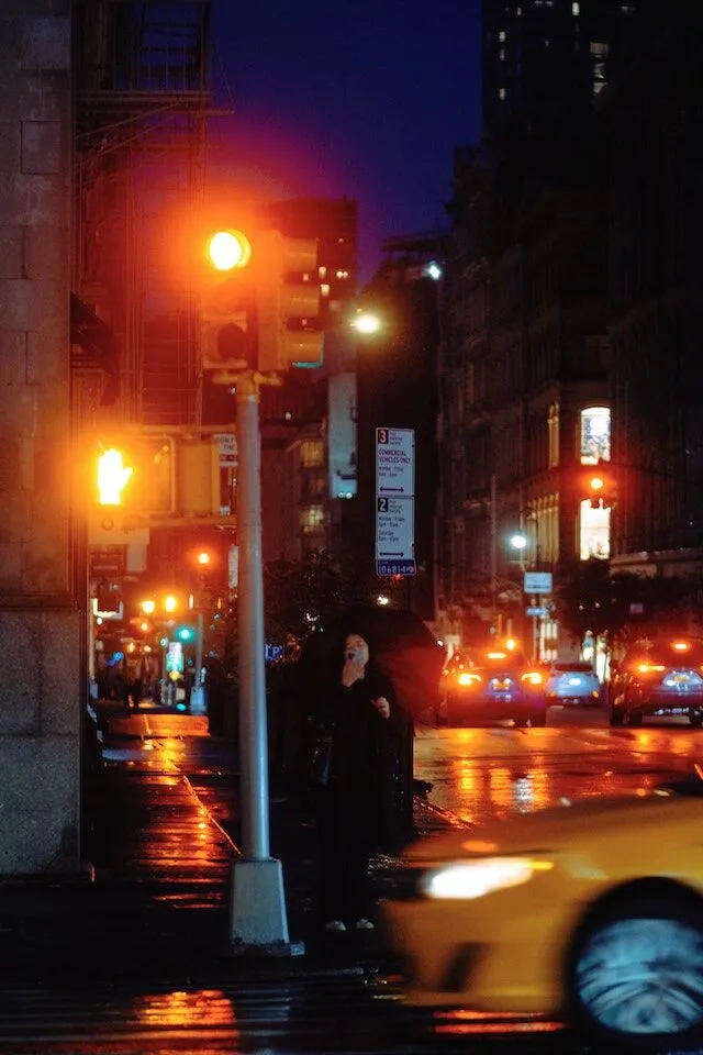 Traffic light camera footage used as evidence in a car accident City intersection at night with glowing traffic lights and wet streets