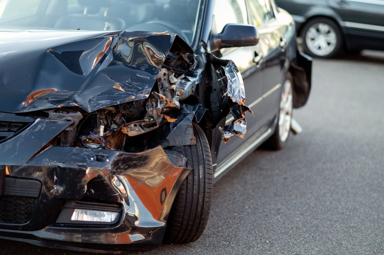 Close-up of damaged car part after accident showing broken metal and scratches Front-end damage to a car after an Illinois accident